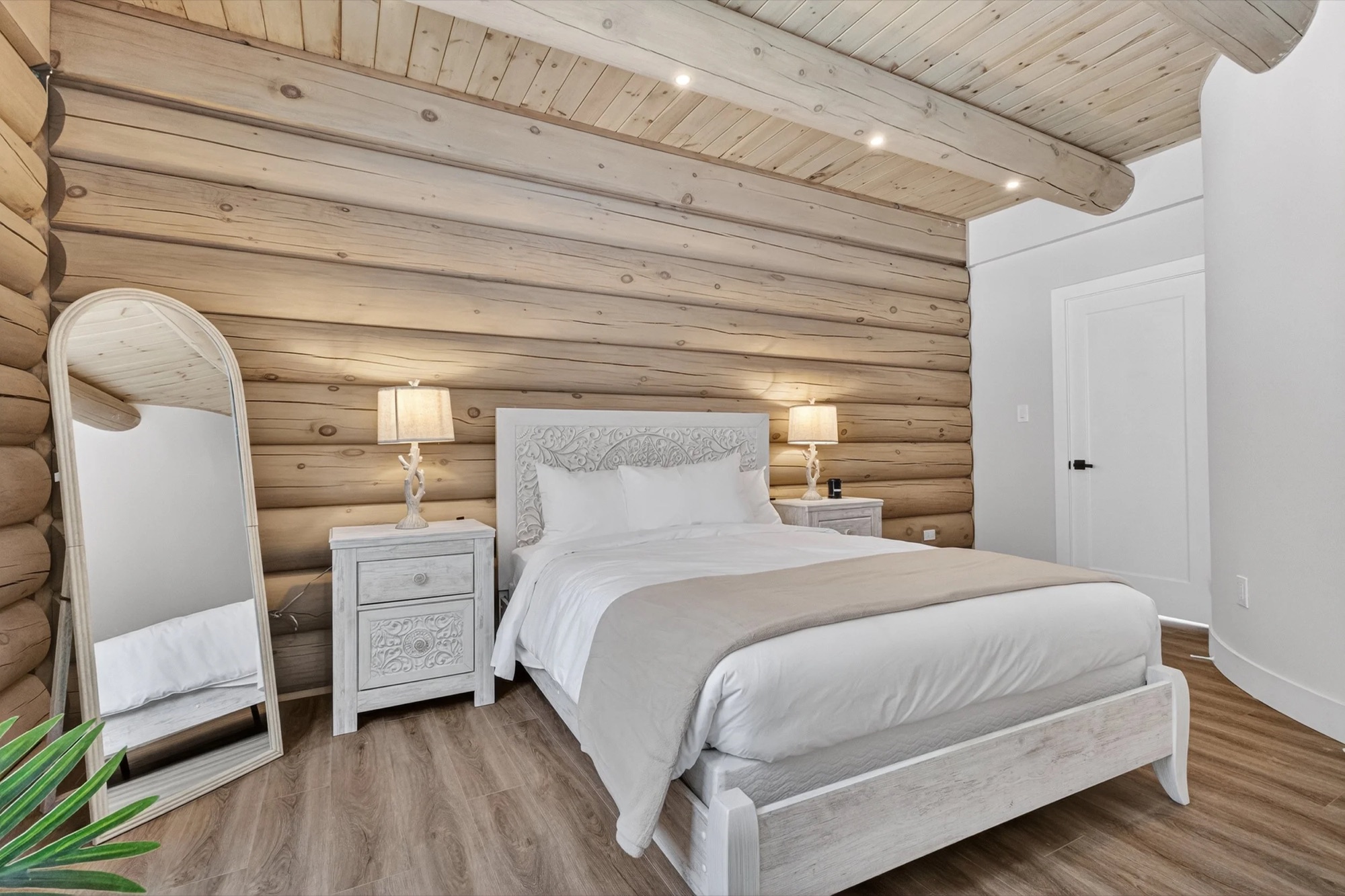 Bedroom 2 — queen bed against the original log wall